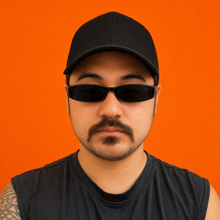 Noah Licata portrait, orange background, black cap and sunglasses